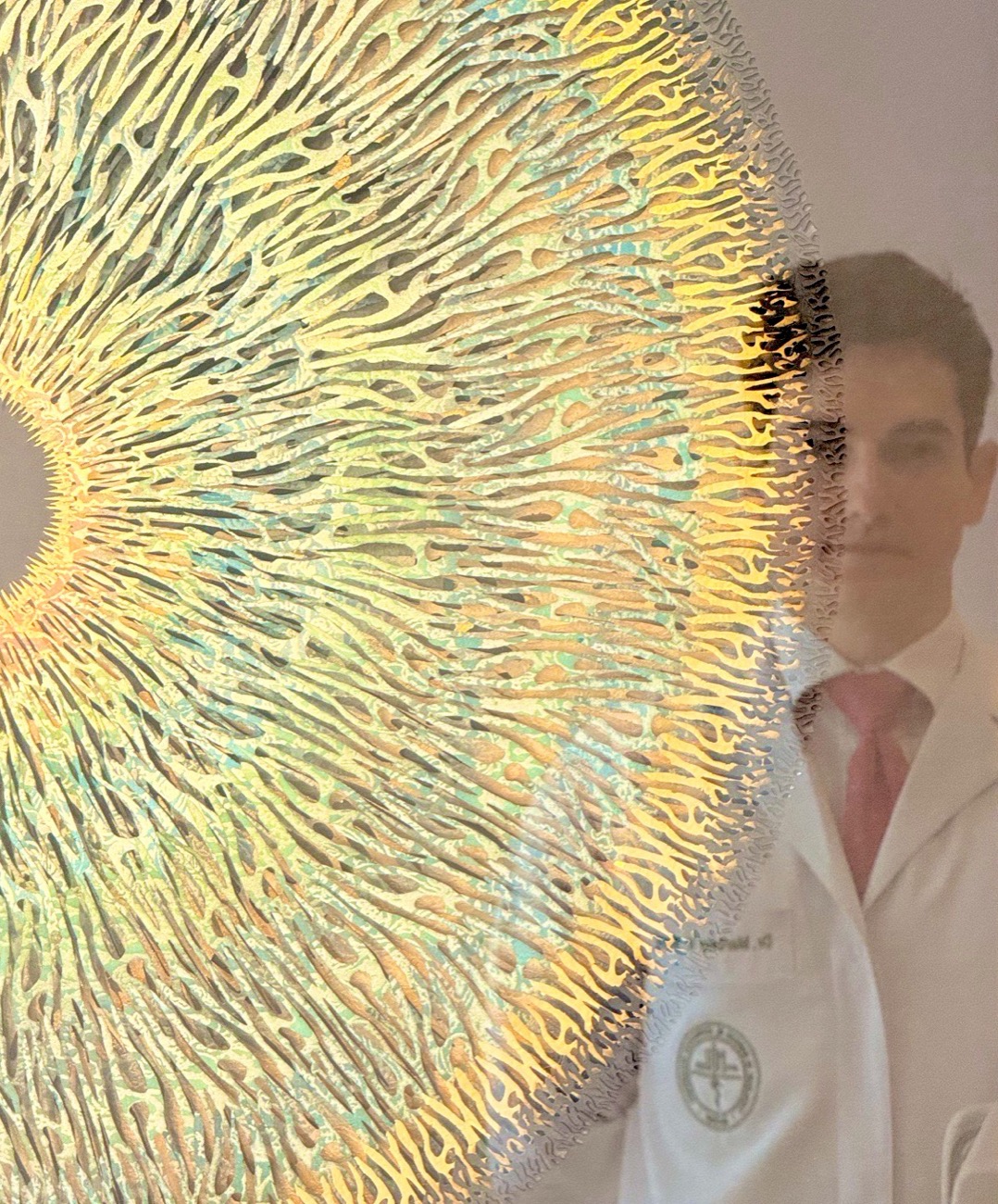Artwork of a human iris displayed at the office, with Dr. Marcelo Muce reflected in the glass