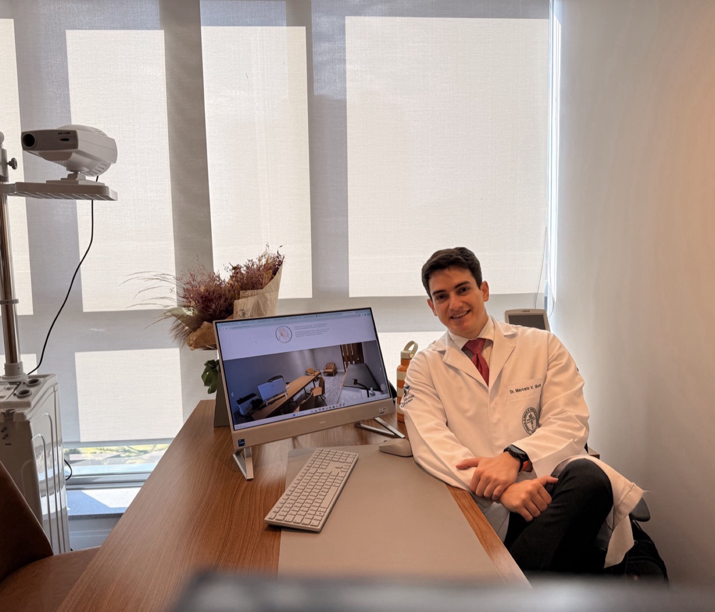 Dr. Marcelo Muce in a white coat at his consultation desk